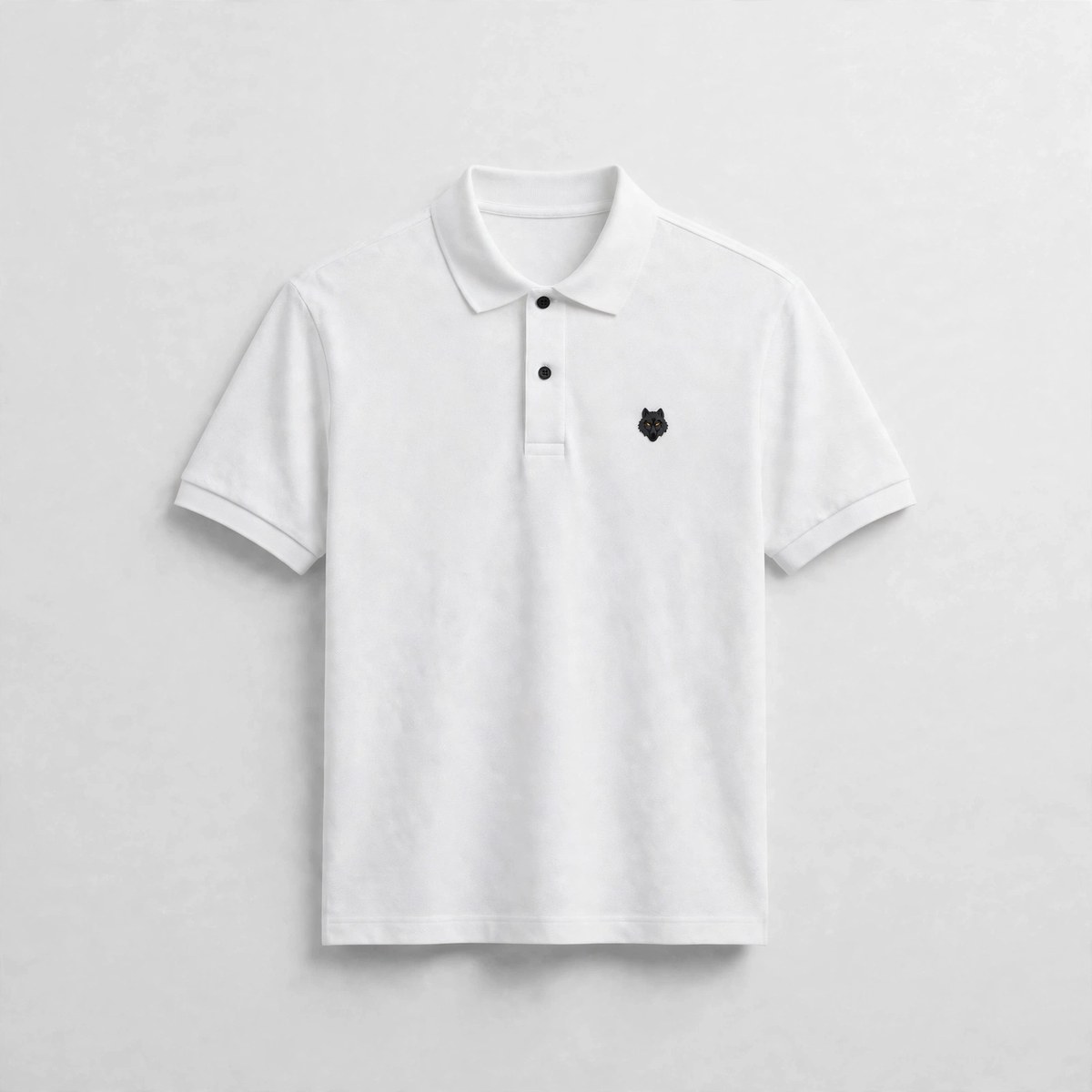 The White Polo — white polo shirt with the black embroidered wolf emblem, coming soon