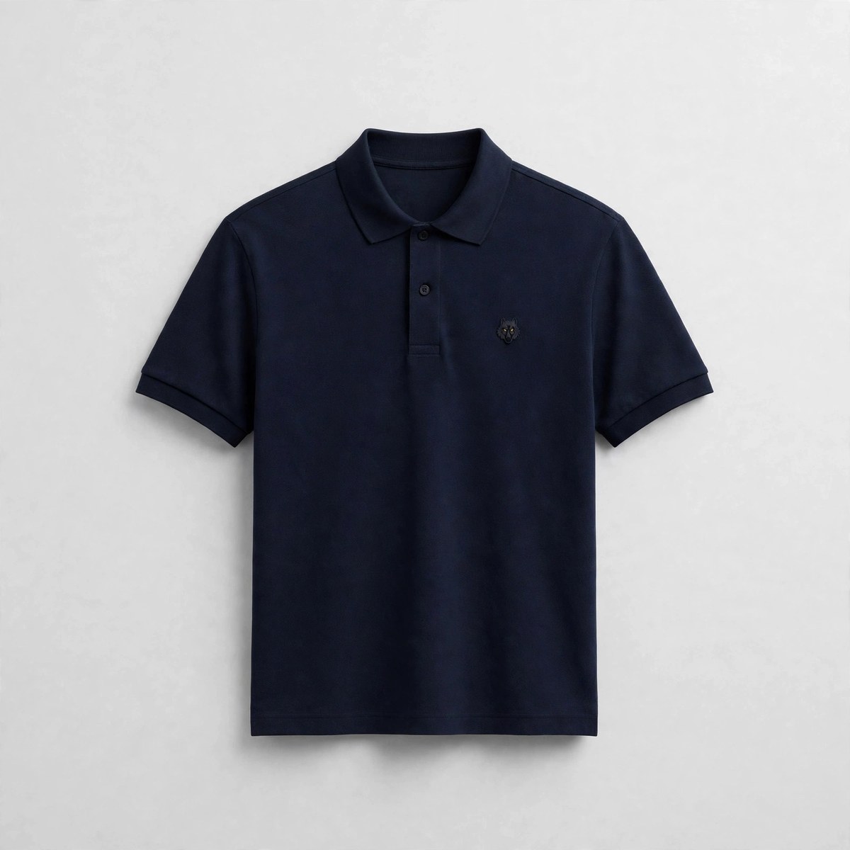 The Navy Polo — navy blue polo shirt with the embroidered wolf emblem, coming soon